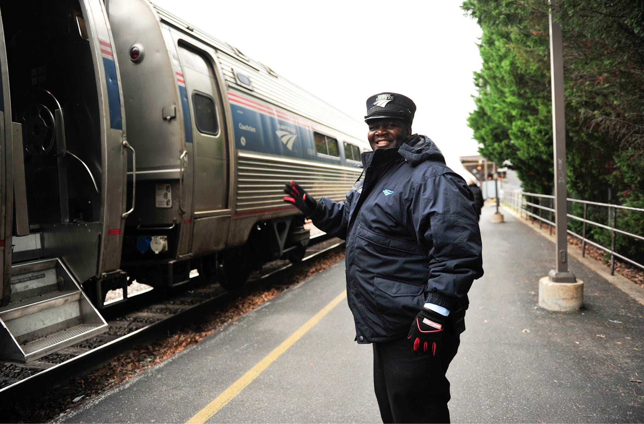 happy smiling man standing at nc passenger rail train